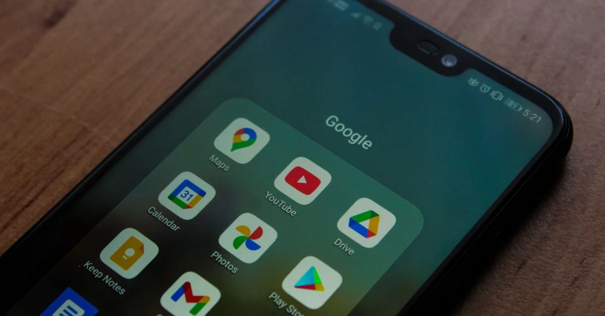 Gros plan sur un smartphone affichant diverses applications Google sur son écran.