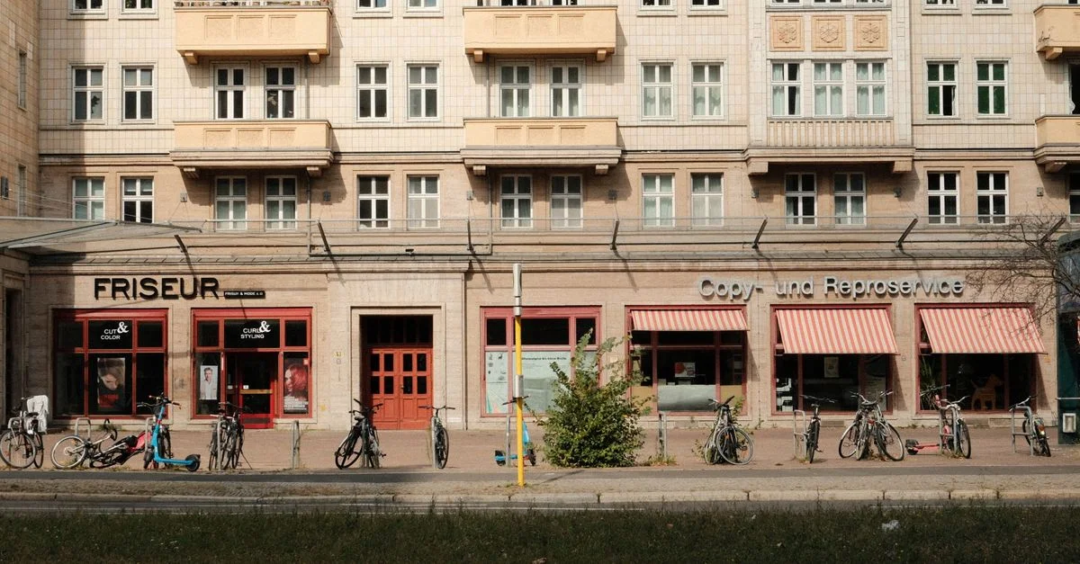 Vue de rue à Berlin par une journée ensoleillée, avec des vélos garés et des commerces de proximité.