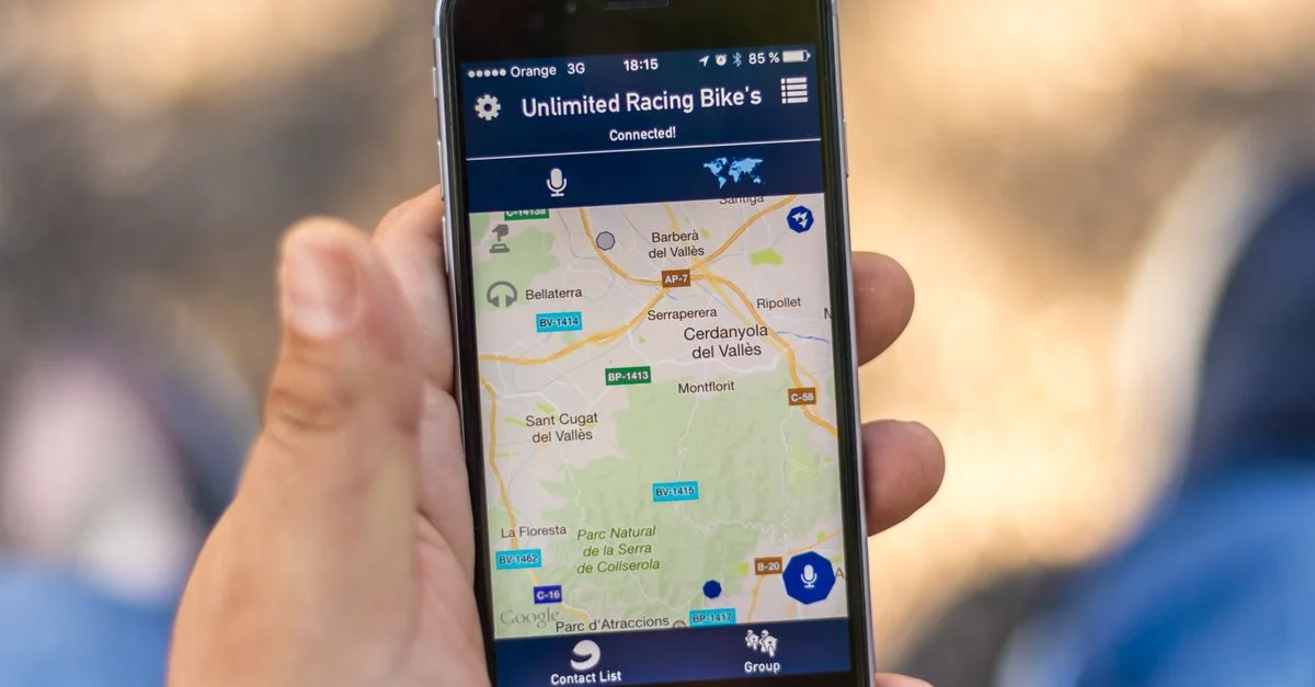 Main tenant un smartphone affichant une application de carte GPS avec des données de localisation.