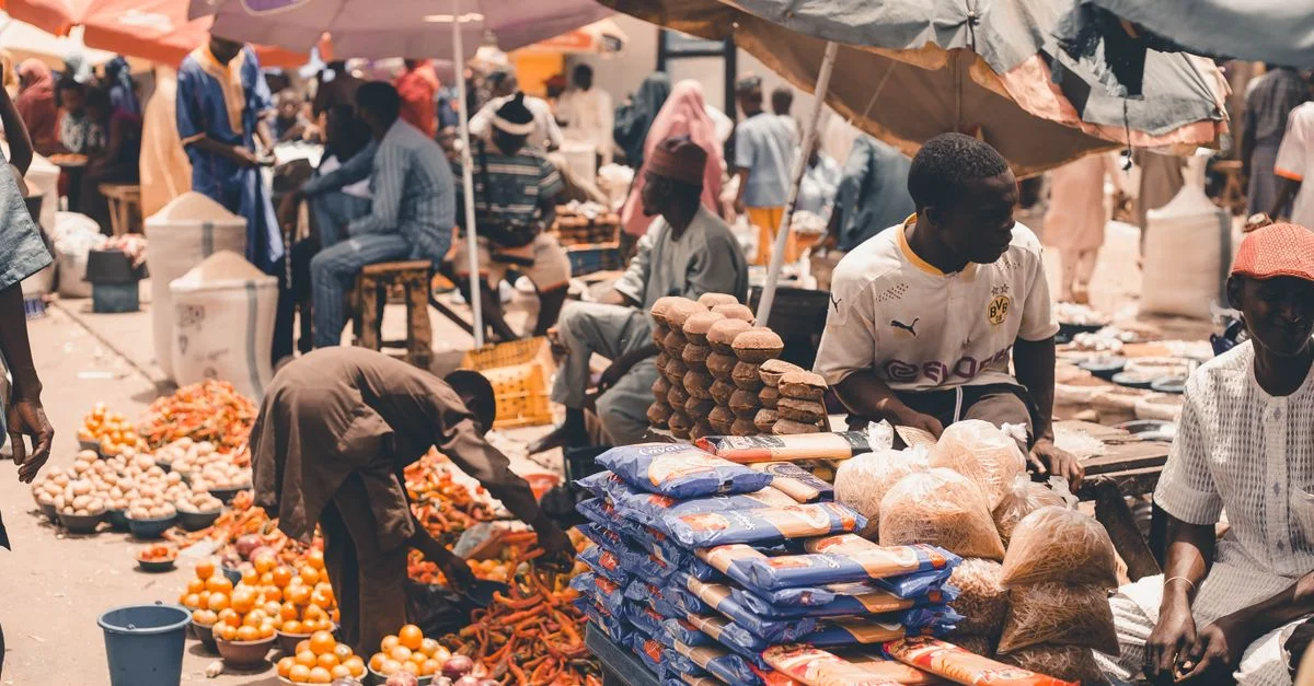 Scène de marché animée présentant des produits frais et des vendeurs sous des parapluies colorés, capturant l'essence du commerce local.